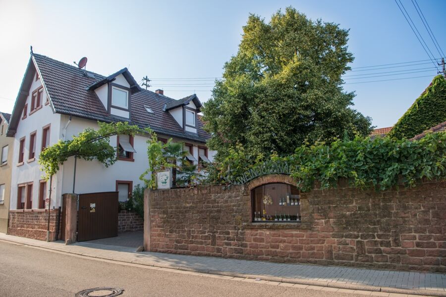 Hofeinfahrt mit schöner Buntsandsteinmauer im Vordergrund
